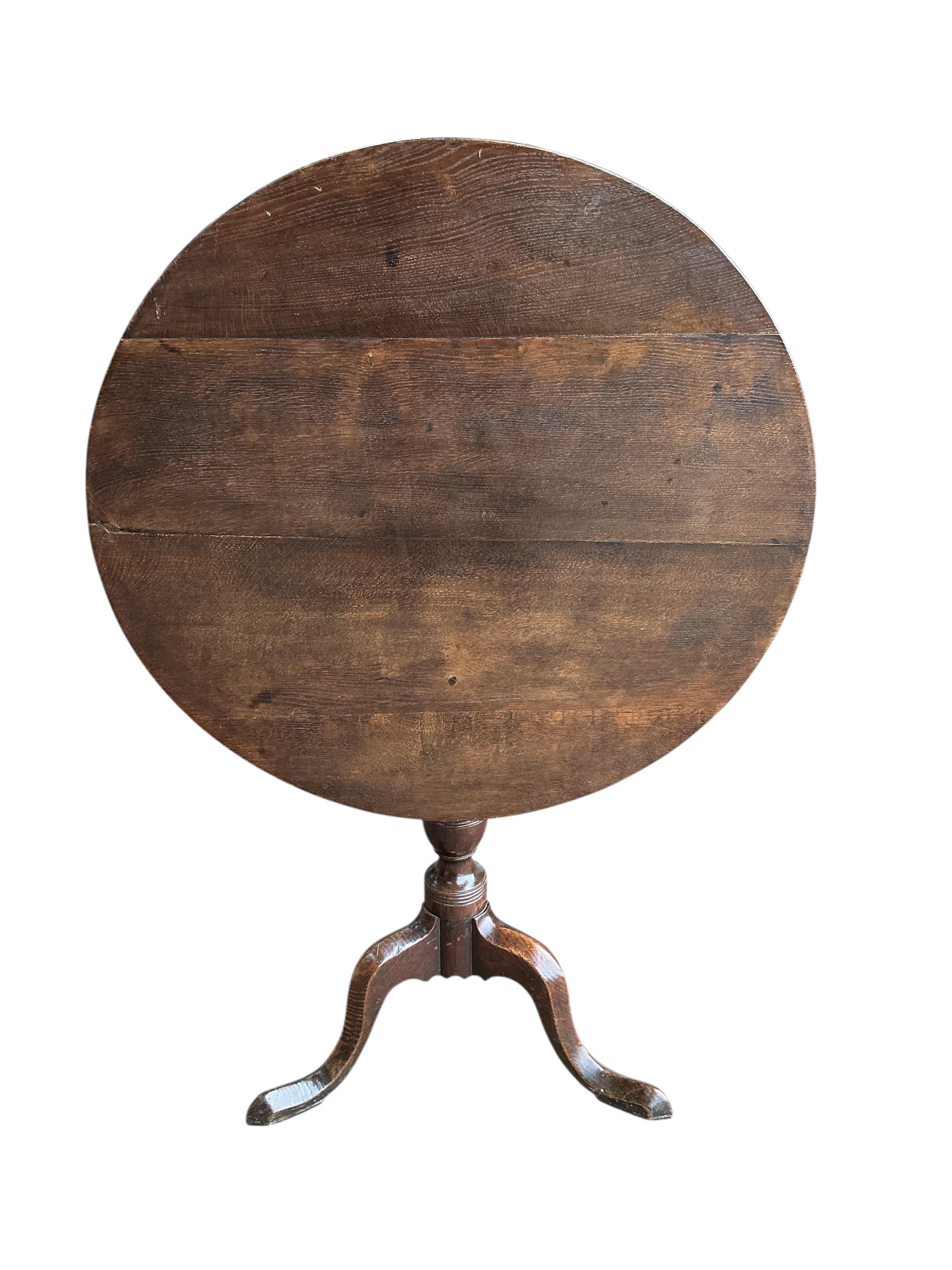 An early 19th century circular oak tilt top tripod tea table, diameter 76cm, height 72cm